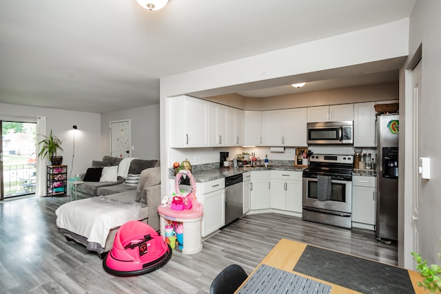 kitchen featuring white cabinets, stainless steel appliances, tasteful backsplash, and light hardwood / wood-style flooring