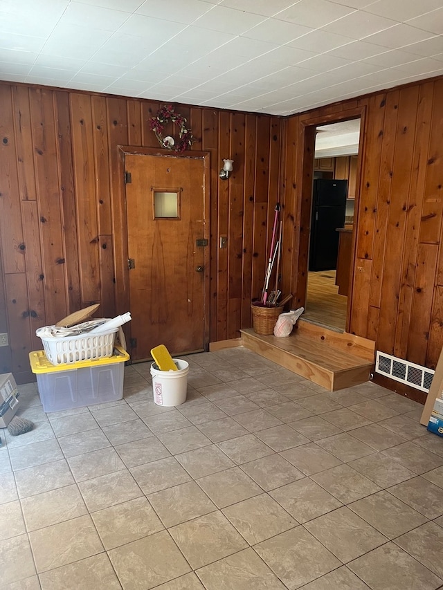 interior space with wood walls and tile patterned floors