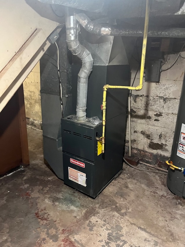 utility room featuring water heater and heating unit