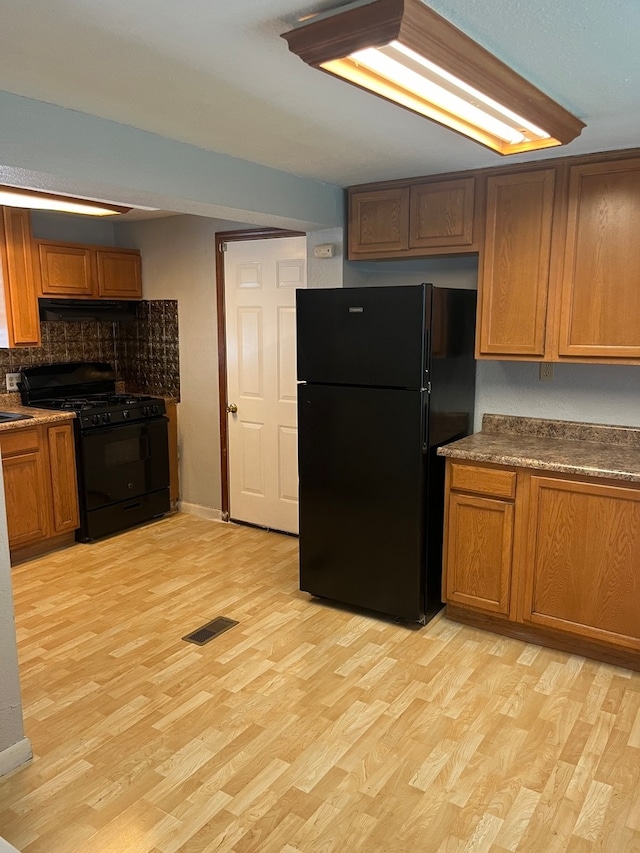 kitchen with black appliances and light hardwood / wood-style floors