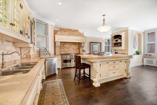 kitchen with custom exhaust hood, hanging light fixtures, appliances with stainless steel finishes, sink, and a center island