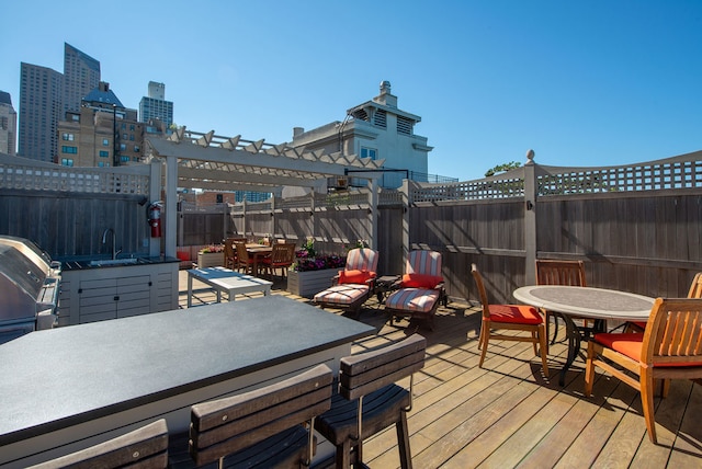 wooden terrace featuring grilling area, sink, and a pergola