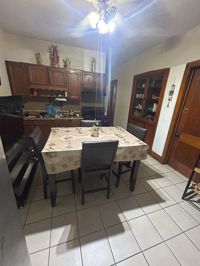 kitchen with a textured ceiling, backsplash, light tile patterned floors, and ceiling fan