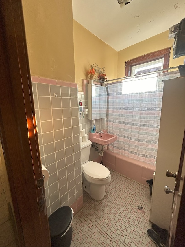 full bathroom featuring tile walls, toilet, sink, and shower / bath combo with shower curtain