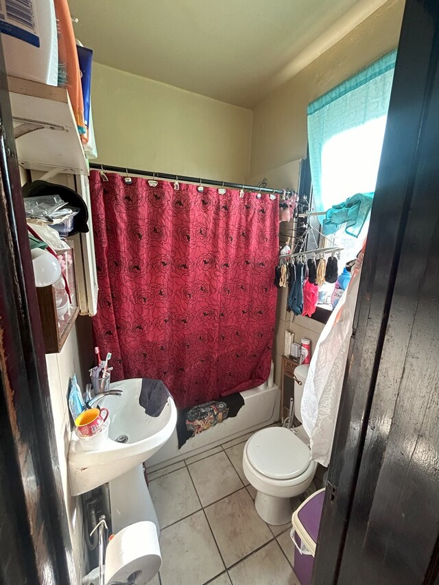 bathroom featuring tile patterned flooring, toilet, and shower / tub combo with curtain