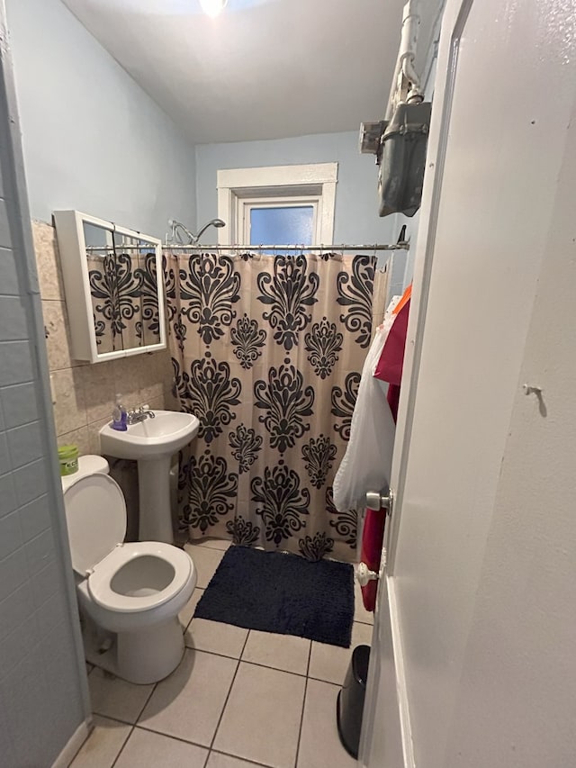 bathroom with toilet, tile patterned floors, and walk in shower