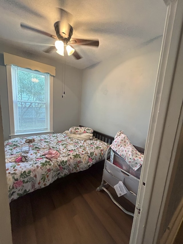 bedroom featuring a textured ceiling, ceiling fan, and hardwood / wood-style floors