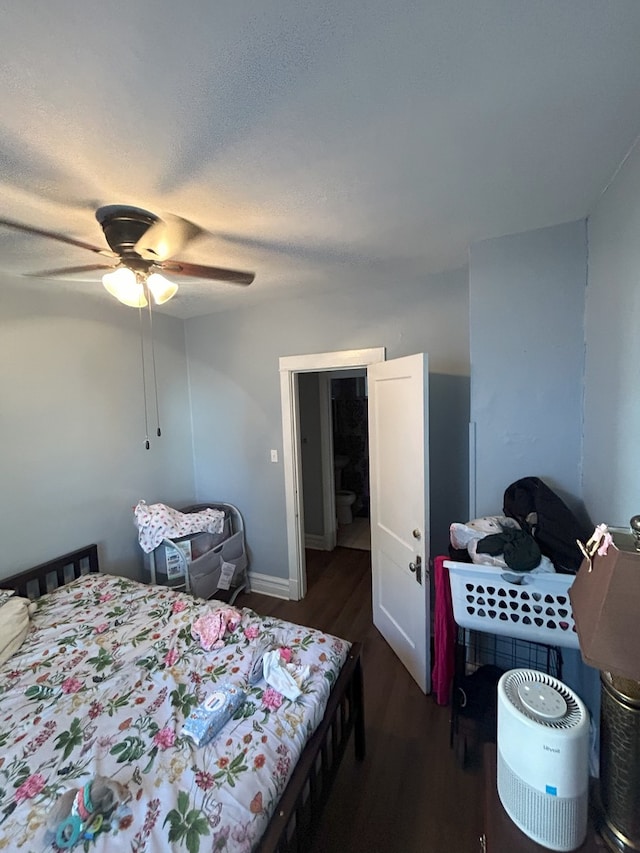 bedroom with ceiling fan, dark hardwood / wood-style floors, and a textured ceiling