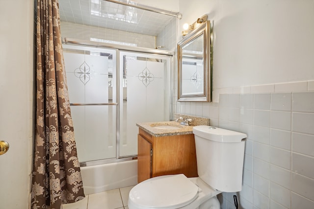 full bathroom with tile patterned floors, toilet, tile walls, shower / tub combo with curtain, and vanity