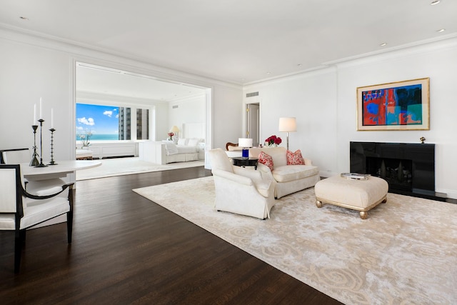 living area with recessed lighting, wood finished floors, a fireplace, and crown molding