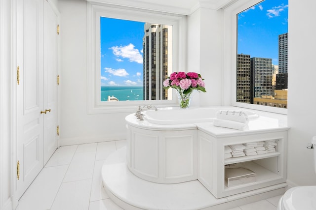 bathroom featuring tile patterned floors, a garden tub, and baseboards