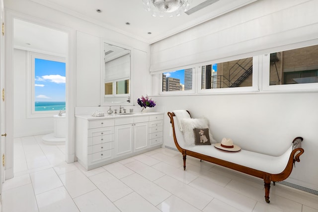 bathroom with a freestanding bath, ornamental molding, vanity, and tile patterned flooring