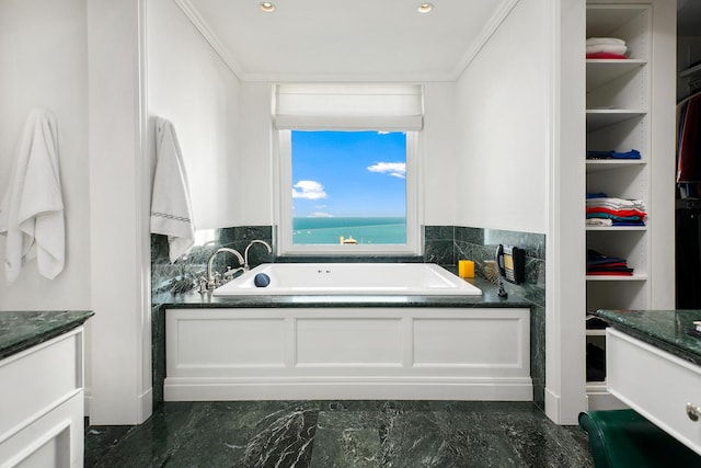 full bathroom with vanity, a garden tub, a spacious closet, and crown molding