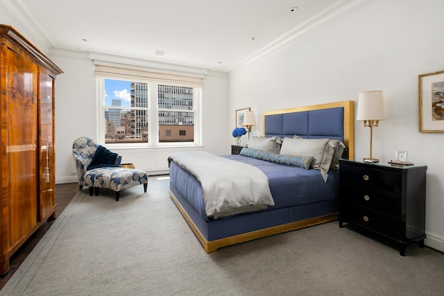 carpeted bedroom featuring crown molding and baseboards