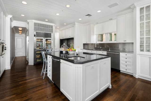 kitchen with visible vents, dark wood-type flooring, appliances with stainless steel finishes, white cabinetry, and dark countertops