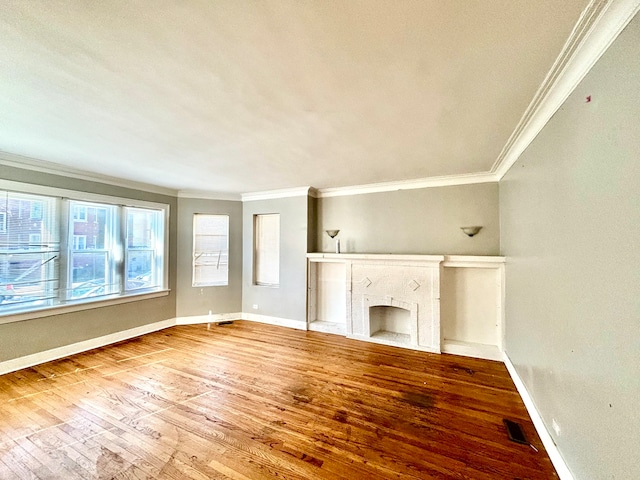 unfurnished living room featuring crown molding, a premium fireplace, and hardwood / wood-style floors