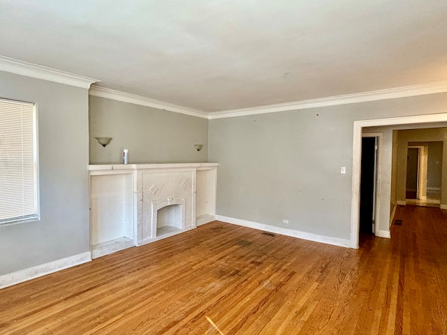 unfurnished living room with a premium fireplace, ornamental molding, and hardwood / wood-style flooring