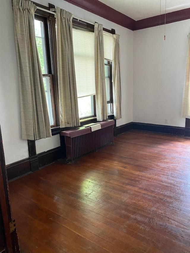 627 Hennepin St, Lasalle, IL 61301 - empty room with radiator heating unit, plenty of natural light, baseboards, and wood-type flooring