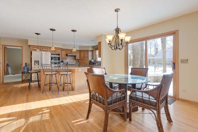 dining room with an inviting chandelier and light hardwood / wood-style flooring