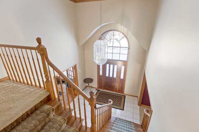 entryway featuring a high ceiling, hardwood / wood-style flooring, and an inviting chandelier