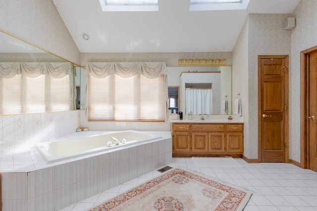 bathroom featuring tiled tub, plenty of natural light, and a skylight