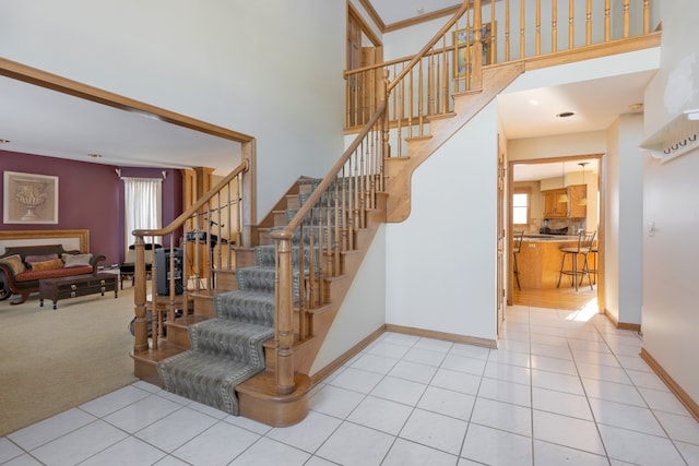 staircase featuring a towering ceiling and carpet floors