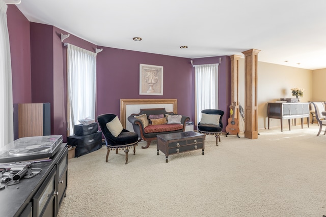 living area with light colored carpet and ornate columns