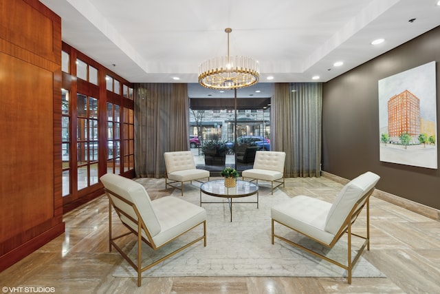 sitting room featuring a chandelier and a tray ceiling