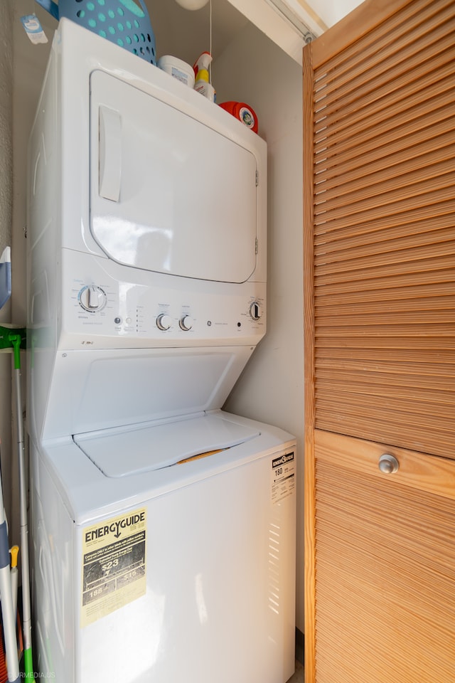 clothes washing area with stacked washer and clothes dryer