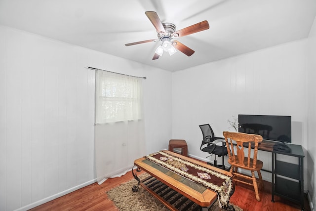 office area featuring wood walls, hardwood / wood-style flooring, and ceiling fan