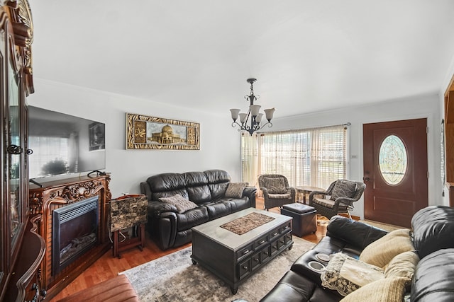 living room with a chandelier, hardwood / wood-style flooring, and ornamental molding