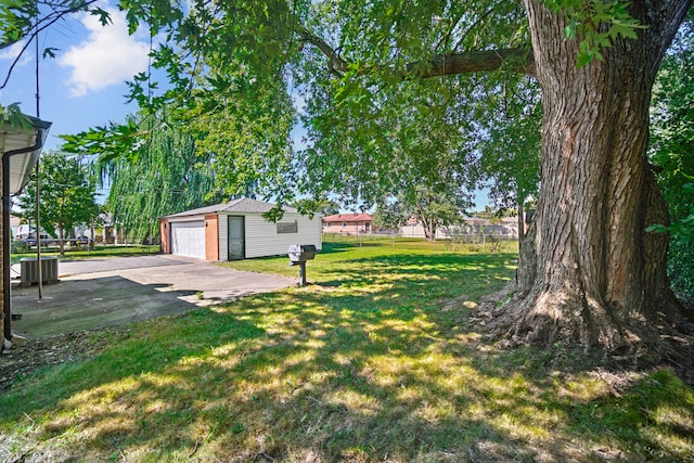 view of yard with an outbuilding, a garage, and cooling unit