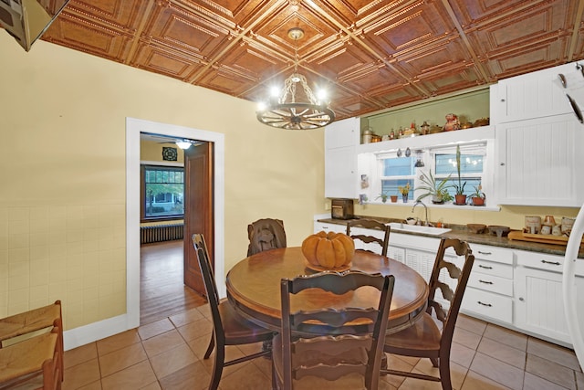 dining space with an inviting chandelier, a wealth of natural light, sink, and light hardwood / wood-style flooring