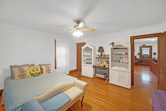 bedroom with ceiling fan, multiple windows, and light hardwood / wood-style floors