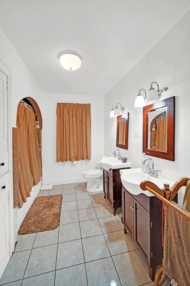 bathroom with toilet, vanity, a shower with shower curtain, and tile patterned floors