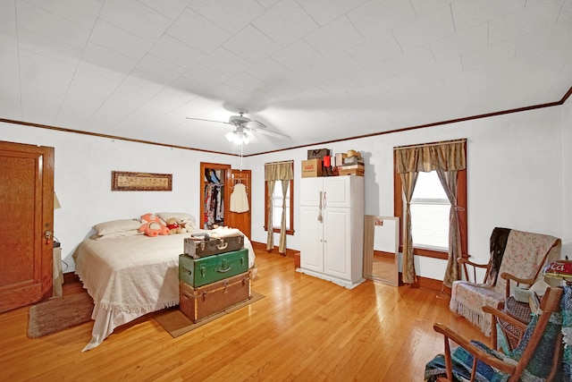 bedroom featuring ceiling fan, light hardwood / wood-style flooring, and ornamental molding