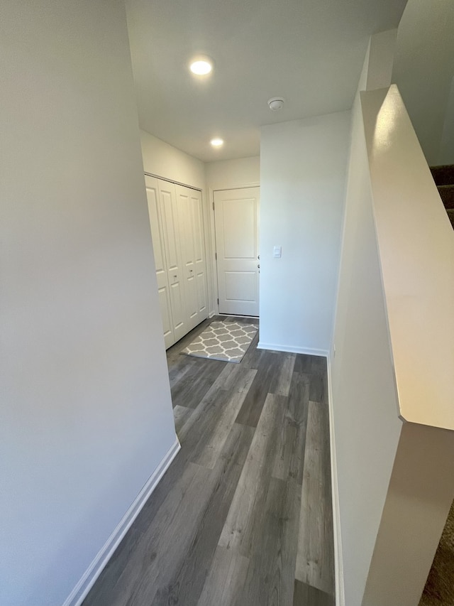 hallway featuring dark wood finished floors, recessed lighting, and baseboards