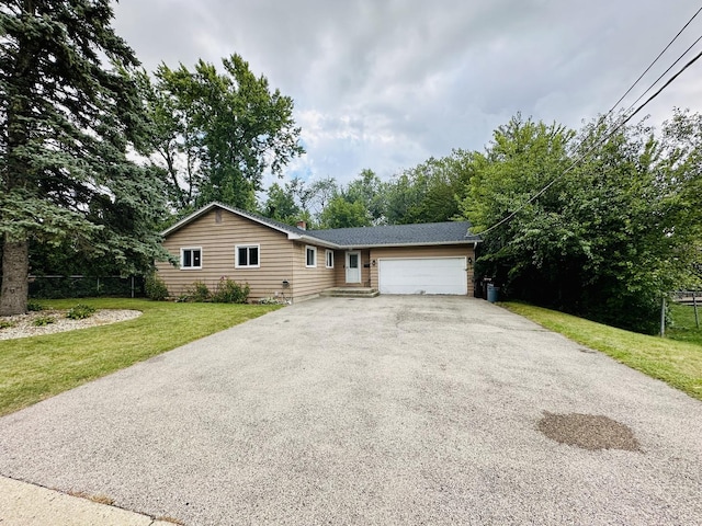 single story home with driveway, a garage, and a front lawn