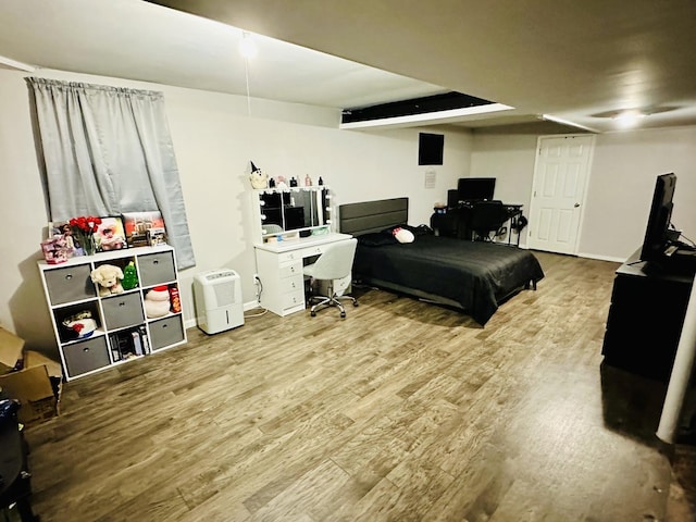 bedroom with wood finished floors and an office area