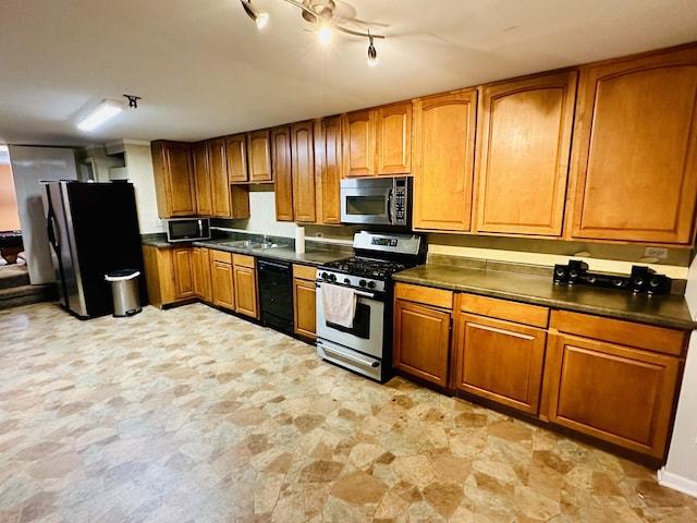 kitchen with black appliances, brown cabinetry, stone finish flooring, and dark countertops