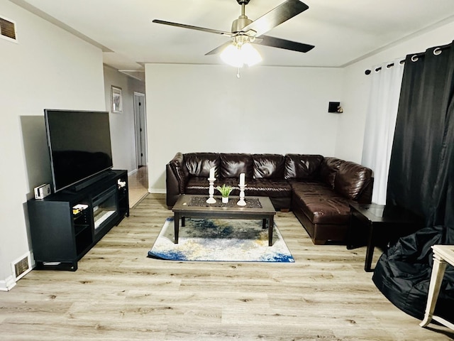 living room with ceiling fan, wood finished floors, and baseboards