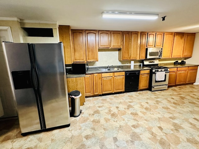 kitchen featuring stainless steel appliances, light stone finish flooring, a sink, and brown cabinets