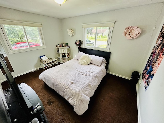 carpeted bedroom with multiple windows and baseboards