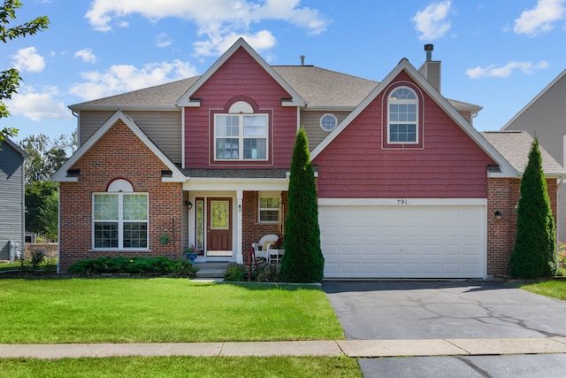 view of property with a garage and a front lawn