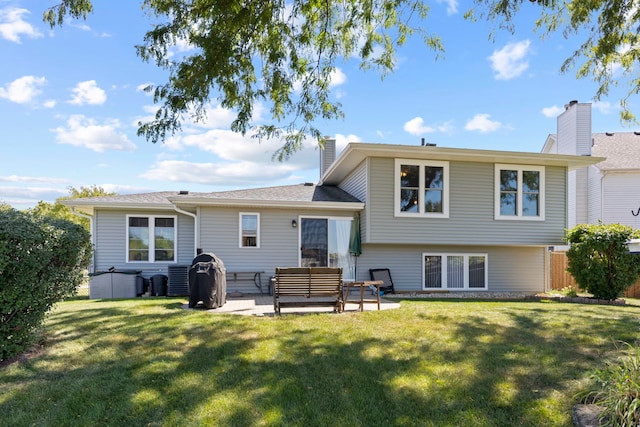 rear view of property with a lawn, a patio, and central air condition unit