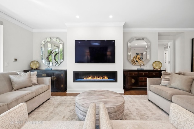 living area featuring a glass covered fireplace, recessed lighting, crown molding, and wood finished floors