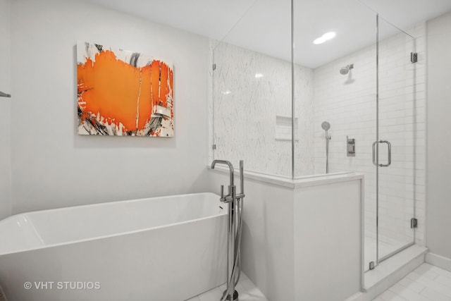 bathroom with a shower stall and a freestanding bath