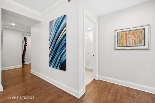 corridor with baseboards, wood finished floors, and crown molding