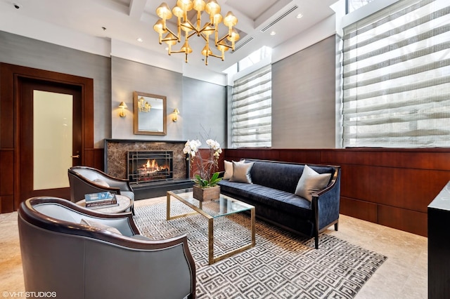 living area featuring wooden walls, a chandelier, a premium fireplace, beam ceiling, and coffered ceiling