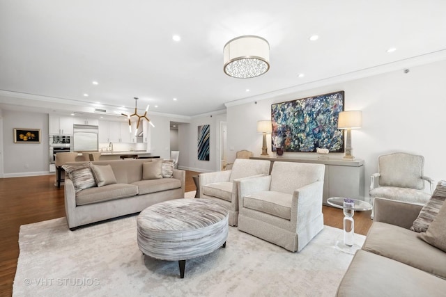 living room featuring recessed lighting, baseboards, wood finished floors, and crown molding